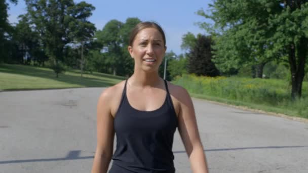 千禧年女运动员跑步后在森林公园散步 凉快了下来 — 图库视频影像