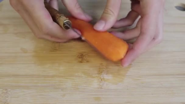キッチンカウンターで料理をしている人 彼は野菜 ニンジン ナイフで切っている — ストック動画