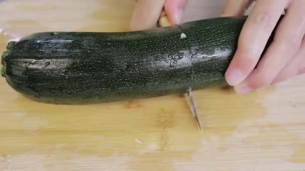 キッチンカウンターで料理をしている人 ナイフで野菜を切ってスライスを作ってる — ストック動画