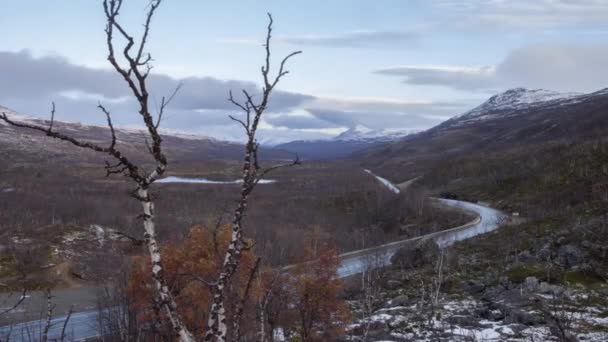 山岳地帯を通る道路の時間の経過 部分的に曇りの空と裸の冬の木 — ストック動画