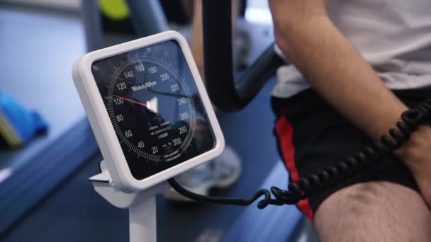 Mann Lässt Sich Blutdruck Abnehmen Während Auf Laufband Trainiert — Stockvideo