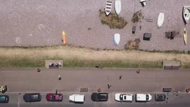 空中トップショット スタティッククロップビーチの上に駐車車が停まっている通りから海に移動します — ストック動画