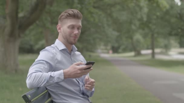 Man Sat Bench Texting Recebe Telefonema Amigo Não Classificado — Vídeo de Stock