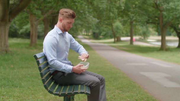 Mężczyzna Siedzi Ławce Jedzenie Lunch Doświadczenia Zgaga Ból — Wideo stockowe