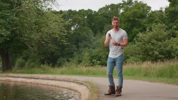 Göl Kenarında Yürüyen Adam Bir Arkadaştan Telefon Alıyor — Stok video