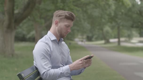 Park Bench Oturan Adam Telefonunda Spor Maçı Seyrediyor — Stok video