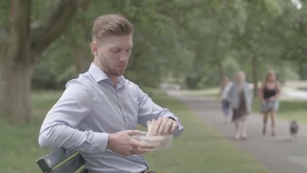 Hombre Sentado Banco Come Almuerzo Experiencias Ardor Del Corazón Ungraded — Vídeo de stock