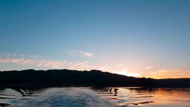 夕日は後ろに残され カメラはボートの真後ろに向けられているので ボートからの波を見ることができますが 日没からサイドへの反射 — ストック動画