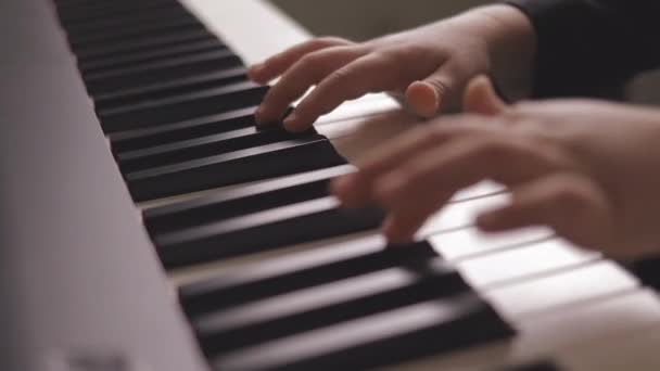 子供は電気ピアノで演奏する 少年ピアノを学ぶの側面図 ピアノキー 子供の手と指で閉じる — ストック動画