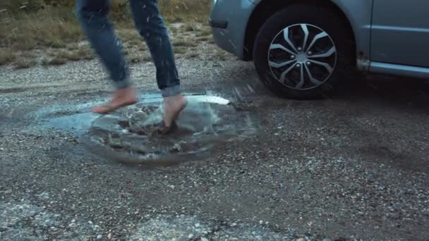 Einige Füße Springen Eine Pfütze Aus Dreckigem Regenwasser — Stockvideo
