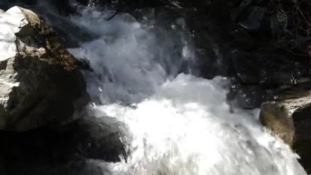 川の岩の上を流れるときに白い水が泡立つ場合は閉じます — ストック動画