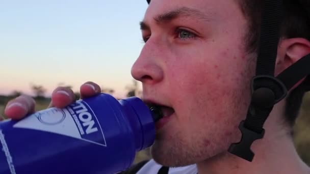 Niño Que Lleva Casco Mira Distancia Mientras Bebe Una Botella — Vídeo de stock