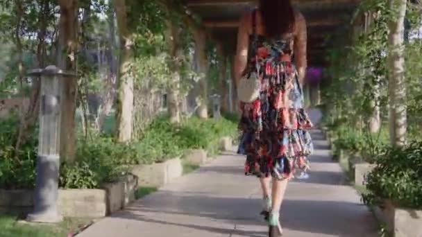全身から撮影された植物のトンネルを歩く少女 — ストック動画