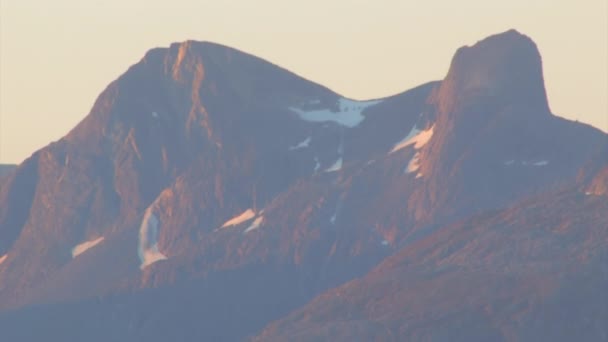 雪の急な山の中で夕日の光で飛んだ 山の顔が赤く見える — ストック動画