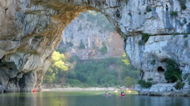 Fransa 'nın ünlü Pont d' Arc 'ında yüzen kanolar tavandan su damlarken ve kuşlar etrafta uçarken