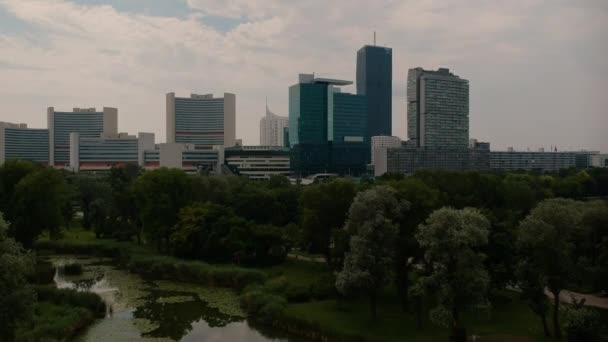 Donaustad Skylinepull Out Schot Achter Groen Park Met Vijver Aerial — Stockvideo