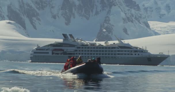 乗客とゾディアックは南極で氷山を探索するために船を出発します — ストック動画