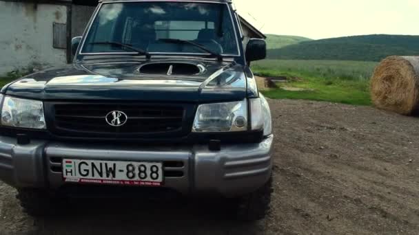 Jeep Auf Einer Wiese Mit Scheune Und Heuhaufen Hintergrund Von — Stockvideo