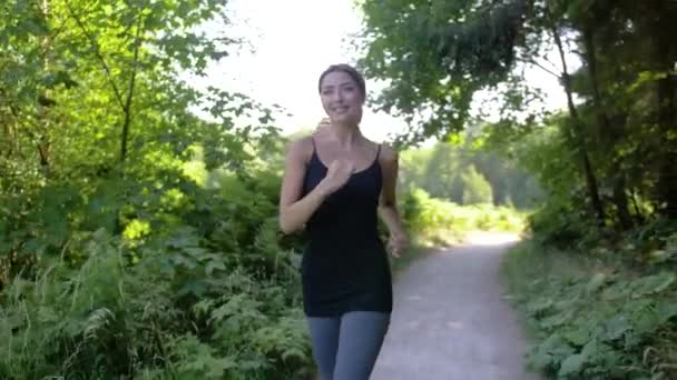 Una Mujer Guapa Joven Rubia Sonríe Mientras Corre Por Sendero — Vídeos de Stock