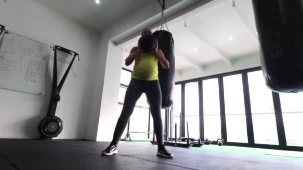 Terhes nő fitness modell csinál testsúly testmozgás egy edzőteremben, hogy tartsa fitt a terhesség harmadik trimeszterében.