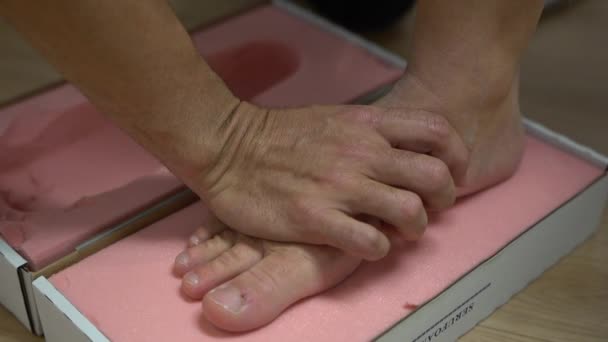 在儿科诊所将脚与泡沫模子连接以测量脚的形状 — 图库视频影像
