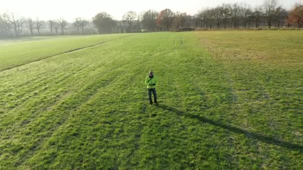 Aerial Drone Shot Flying Away Man Standing Field — Stock Video