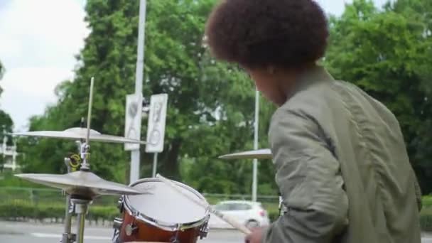 Mladý Afro bubeník venku. Pravděpodobně pouliční interpret.