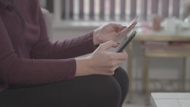 Közelkép fiatal vonzó hölgy segítségével intelligens telefon és hitelkártya, hogy az online vásárlás - Ungraded