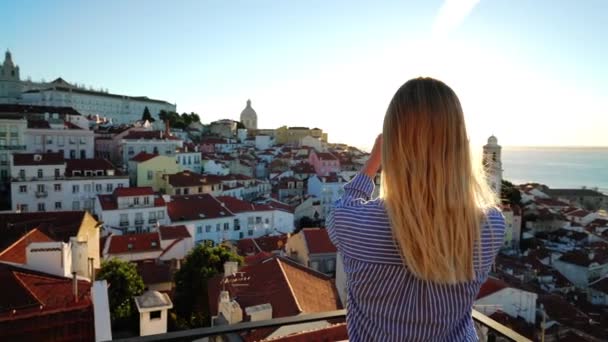 Una Chica Está Tomando Una Foto Del Amanecer Sobre Alfama — Vídeos de Stock