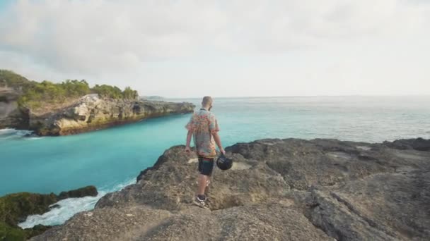 Hombre Sosteniendo Casco Bicicleta Caminando Por Acantilado Día Soleado Lembongan — Vídeos de Stock