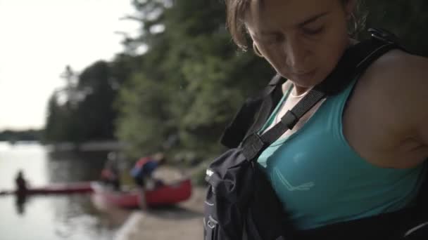 Молодая Женщина Надевает Спасательный Жилет Стоит Прекрасном Берегу Озера Готовится — стоковое видео