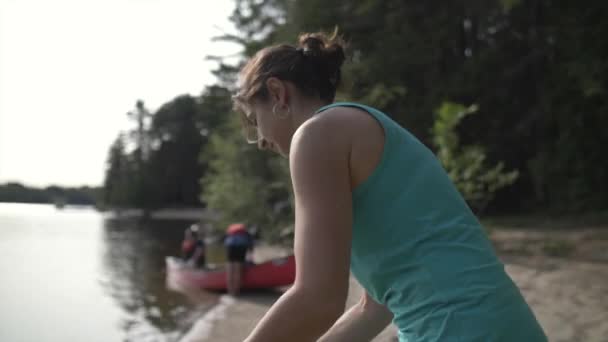 호숫가에 여자가 카약을 준비를 네오프렌 드라이 슈트를 입는다 — 비디오
