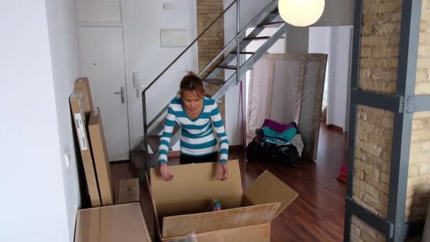 Μια Ασιάτισσα Κοιτάει Όλα Κουτιά Που Είναι Στοιβαγμένα Στο Σαλόνι — Αρχείο Βίντεο