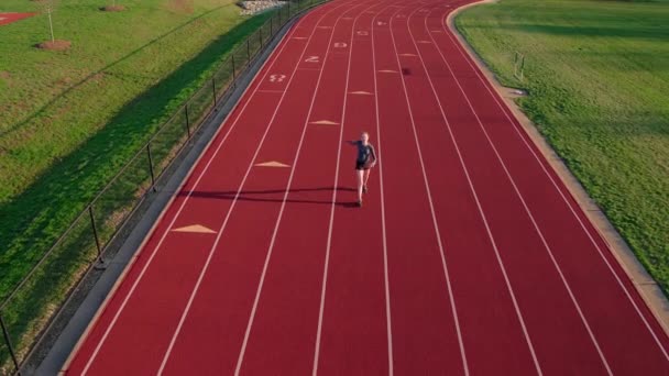一个年轻的女运动员跑完赛程后 走在跑道上冷静下来 — 图库视频影像
