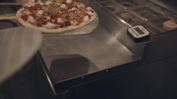 Šéfkuchař vsunuje pizzu do neapolské trouby ve zpomaleném filmu