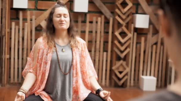 Insegnante Yoga Seduto Sul Pavimento Durante Una Lezione Spiegando Esercizio — Video Stock