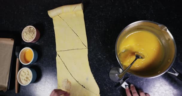 一位女士切羊角面包面团翻滚 用60便士煮美味杏仁羊角面包的头顶照 — 图库视频影像