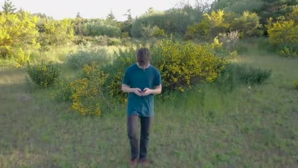 Tienerjongen Die Door Gras Loopt Sms Zijn Telefoon Clip Met — Stockvideo