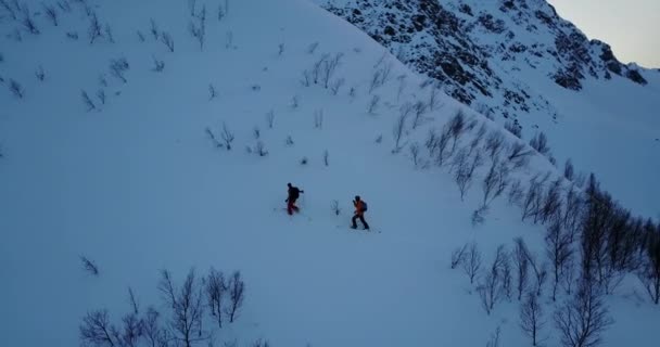 Plano Aéreo Cinematográfico Acercándose Alejándose Dos Esquiadores Con Engranajes Completos — Vídeos de Stock