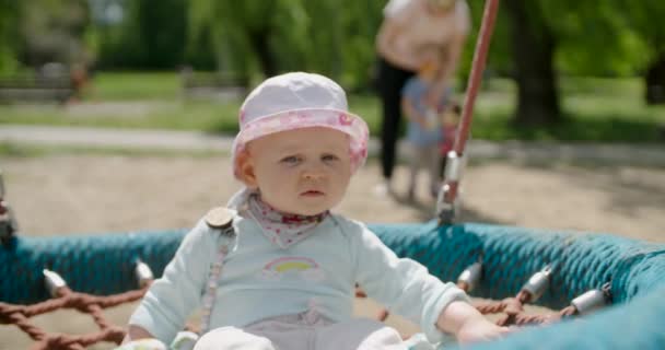 Serious Baby Girl Balançando Teeter Swing Slow Motion — Vídeo de Stock