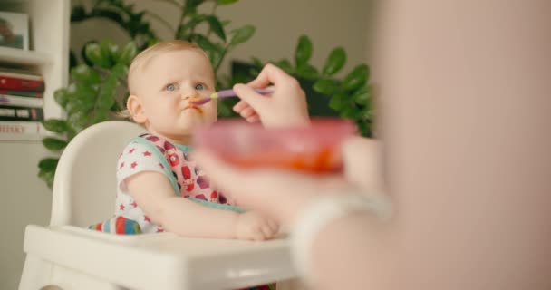 Klein Baby Meisje Eten Babyvoeding Kinderstoel Met Moeder — Stockvideo
