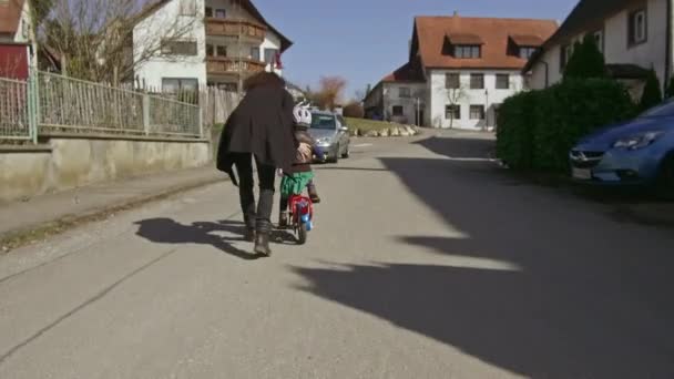 Una Pequeña Niña Aprende Andar Bicicleta Con Mamá — Vídeo de stock