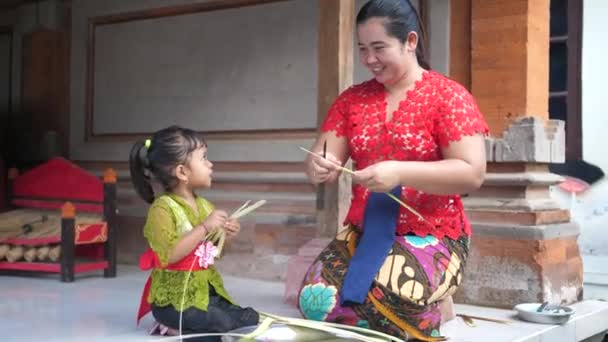 Güzel Küçük Kız Annesinin Bali Deki Palmiye Yapraklarından Çiçek Yapmasına — Stok video