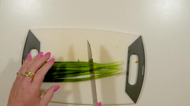 Frauenhände hacken grüne Zwiebeln - Geschwindigkeit rauf und runter