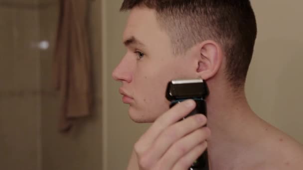 Young Person Trims Face Electric Shaver — Stock Video