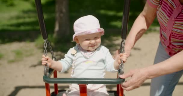 Serious Baby Girl Balançando Teeter Swing Slow Motion — Vídeo de Stock