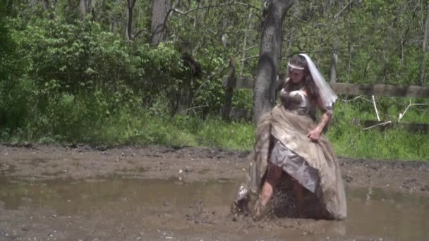 泥だらけの花嫁がゆっくりと動きながら泥だらけの水を蹴り上げる — ストック動画