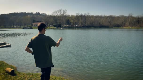 Sazan Avlayan Adam Oltasına Balık Çekmek Için Yemi Suya Atar — Stok video