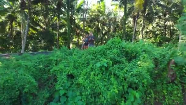 Casal Jovem Voando Drone Através Selva Drone Dolly Out Shot — Vídeo de Stock