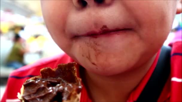 Ruční video záběr mladého asijského chlapce jíst zmrzlinu na kuželu